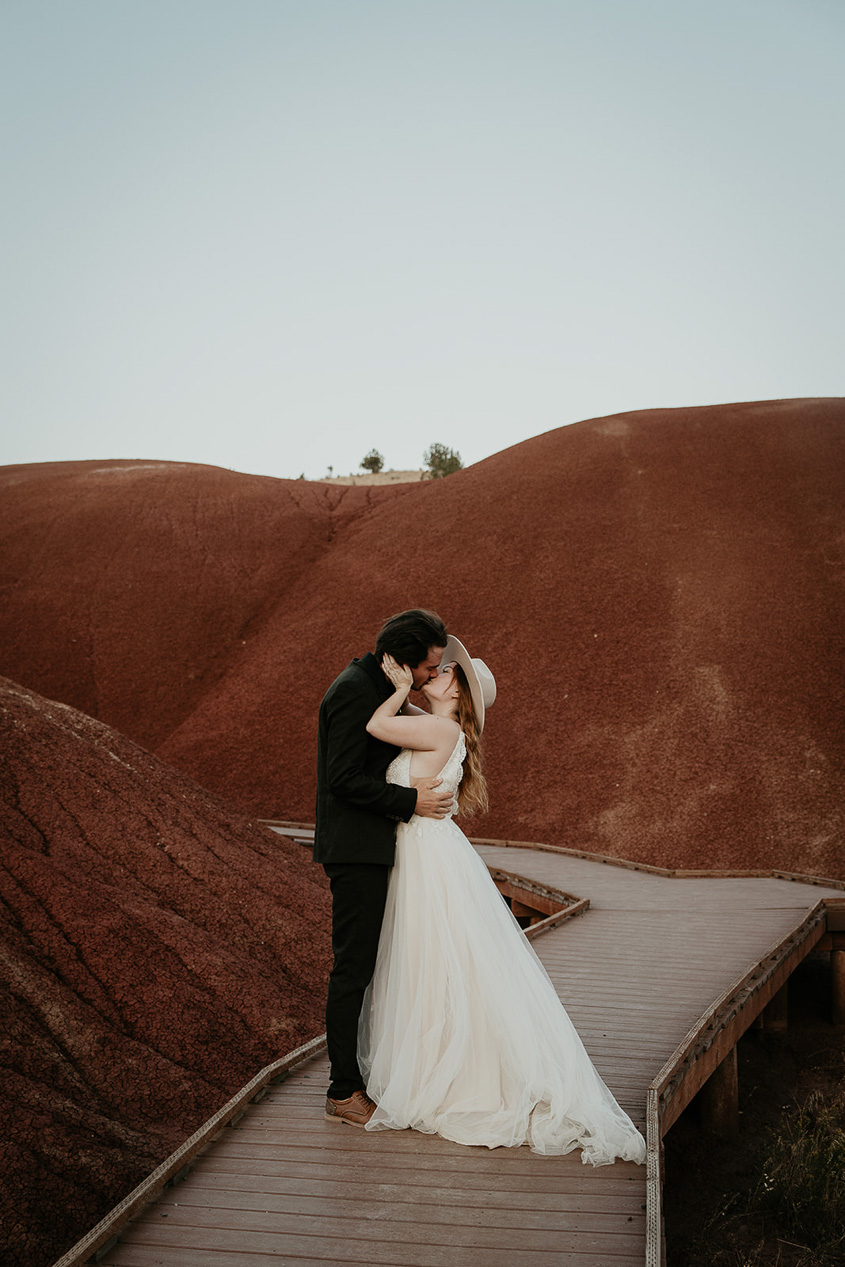 newlyweds kissing in painted rocks, sweetened by how much more inexpensive the cost for them to elope versus have a traditional wedding is.