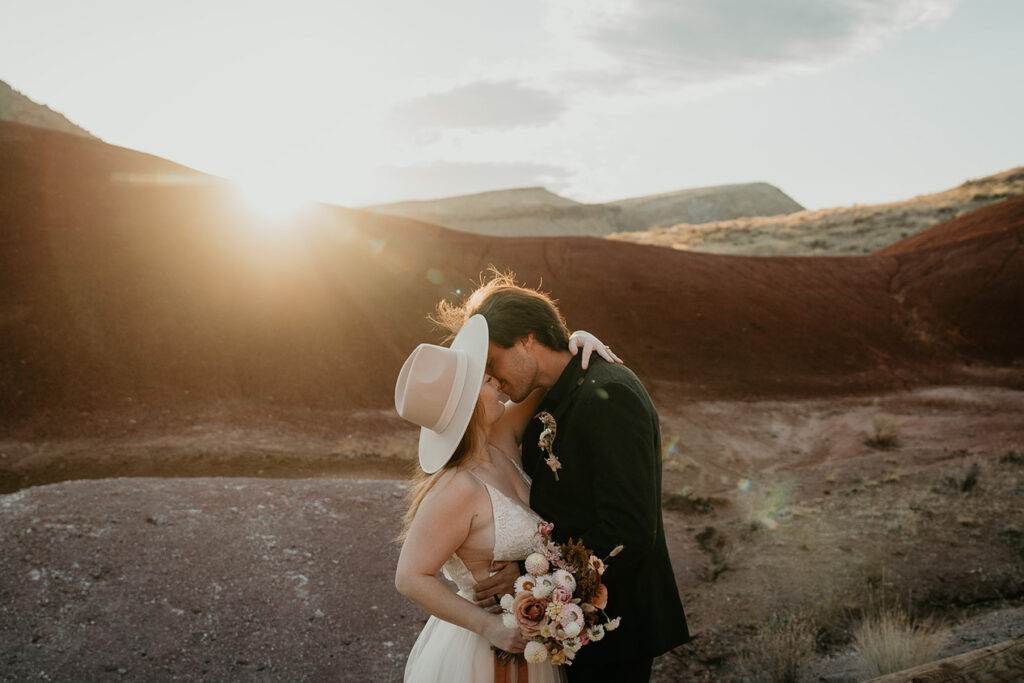 the newlyweds kissing at sunset during their painted hills elopement.
