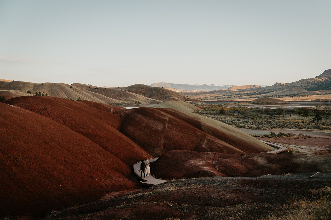 the newlyweds hiking through painted hills during their elopement.