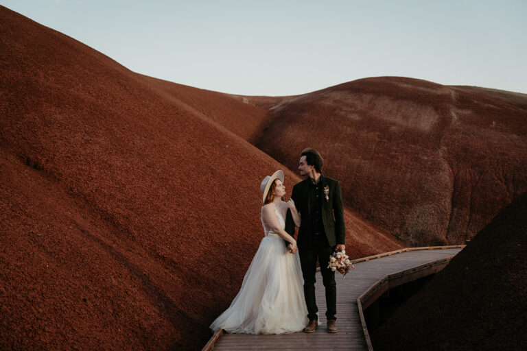 newlyweds on a boardwalk in the middle of painted hills during their elopement.