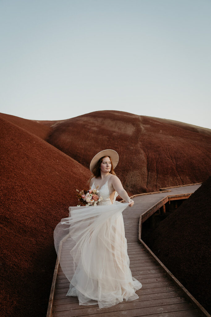 the bride showing off her dress during her painted hills elopement.