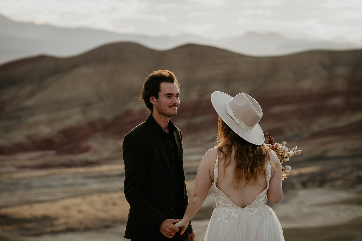 the newlyweds holding hands while looking lovingly into each other's eyes.
