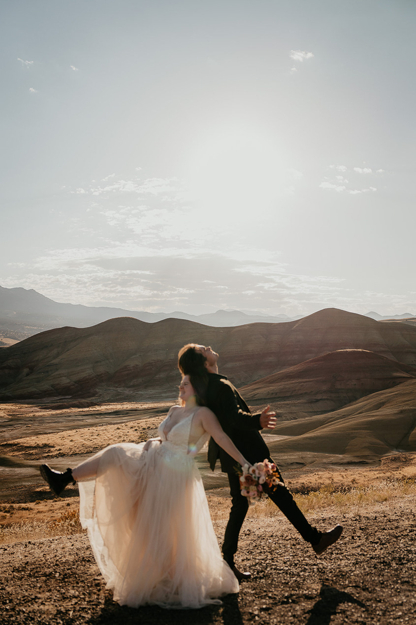 newlyweds dancing in the Oregon backcountry during their painted hills elopement.