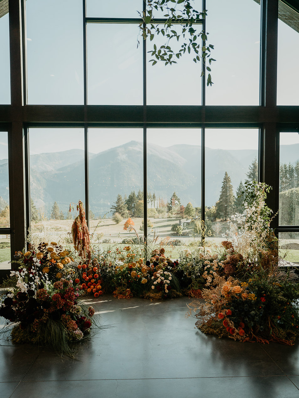 flowers, a glass wall, and views of the mountainside.