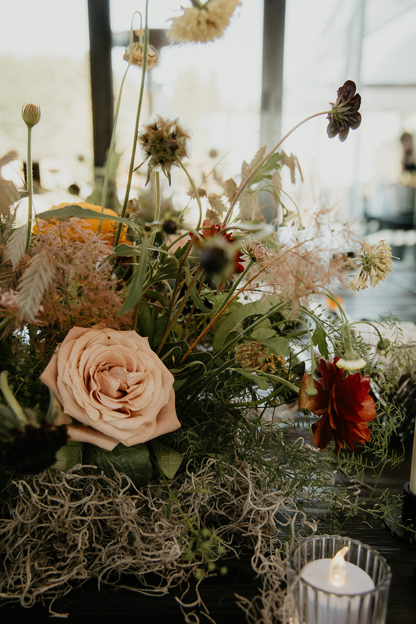 a candle and a bouquet of flowers, decorations for a wind mountain ranch wedding.