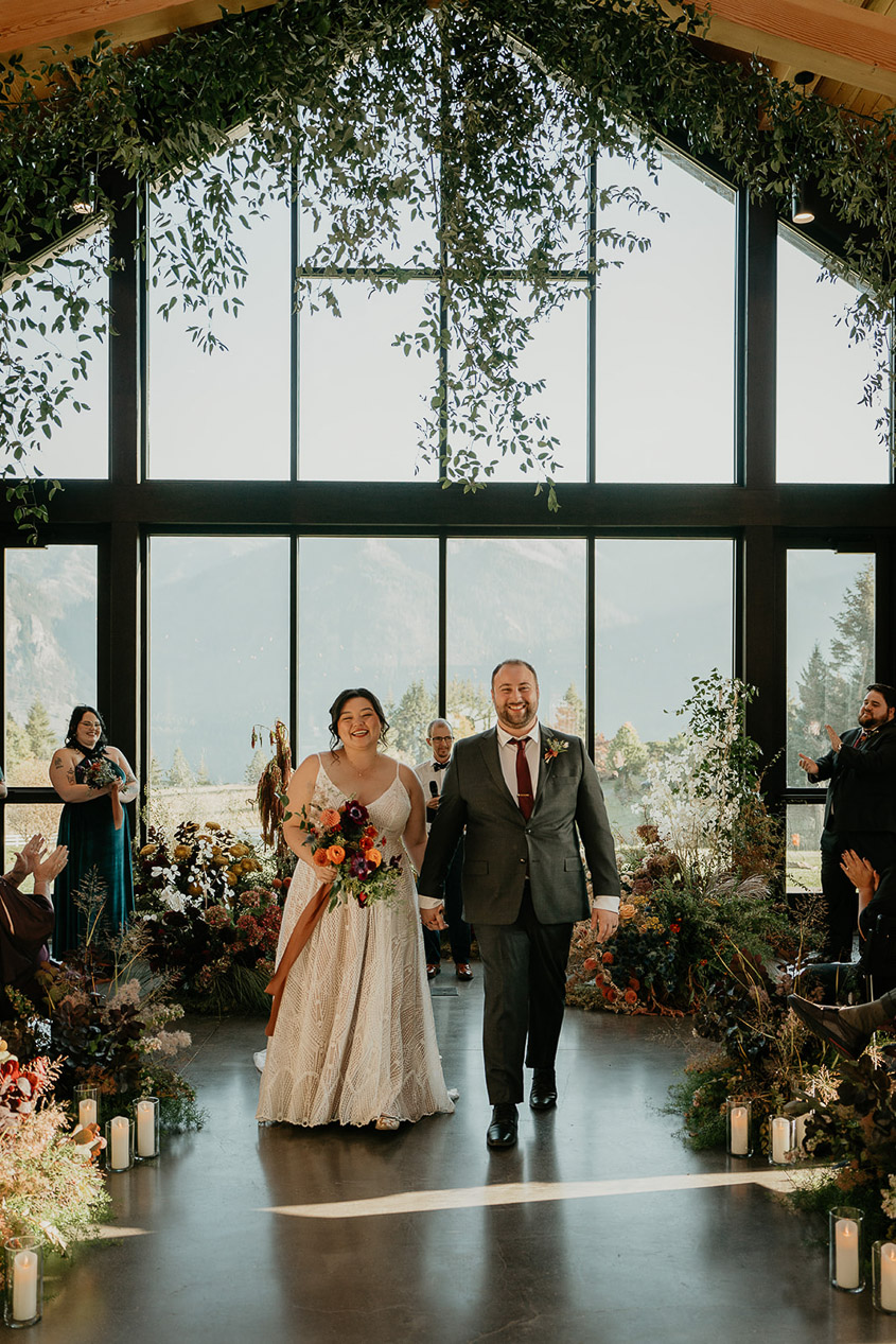 the newlyweds walking down the isle during their wind mountain ranch wedding.
