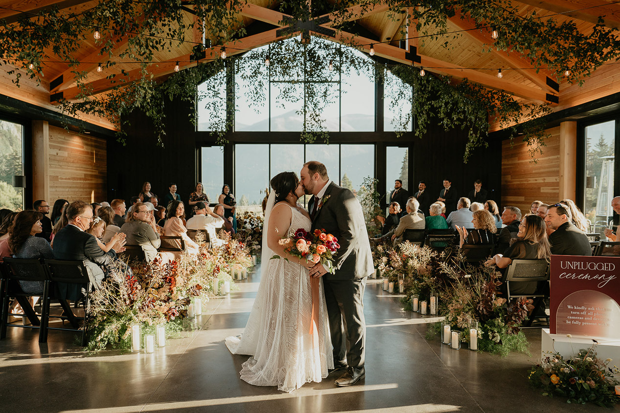 the newlyweds kissing at the end of their wedding ceremony.