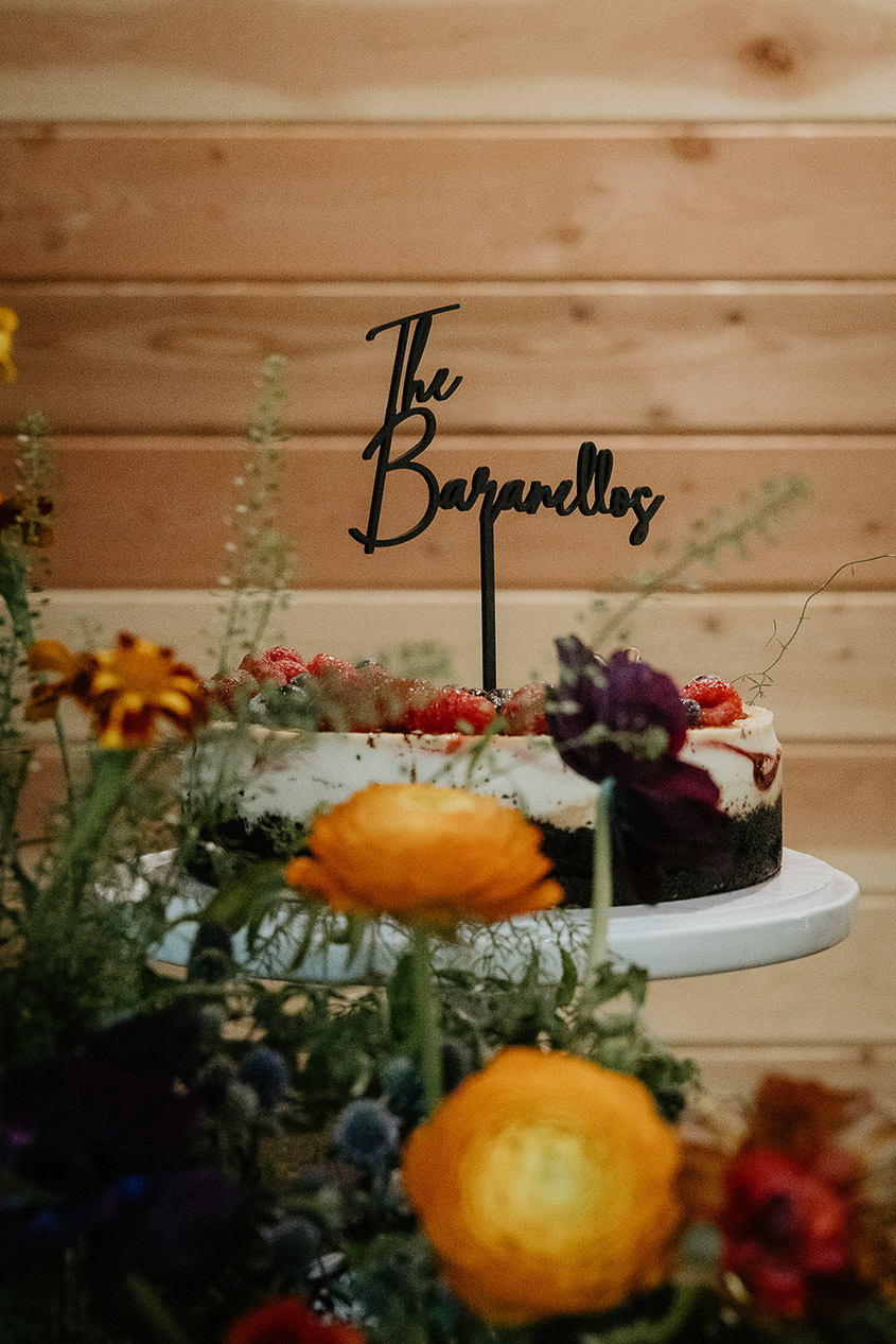 the wedding cake with the couple's last name spelled out on a stick poked into it.