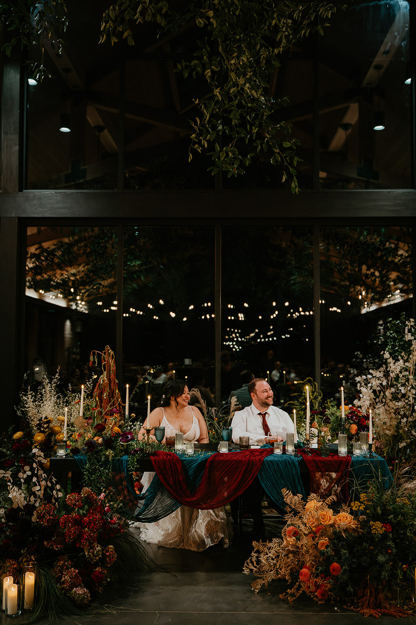 the newlyweds siting at their decorated and floral table.
