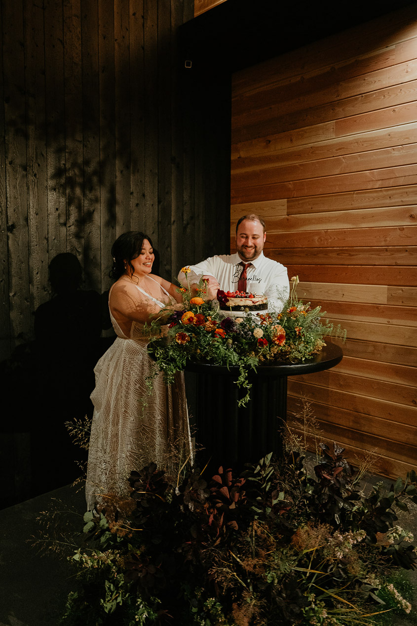 the newlyweds cutting the cake during their wind mountain ranch wedding.