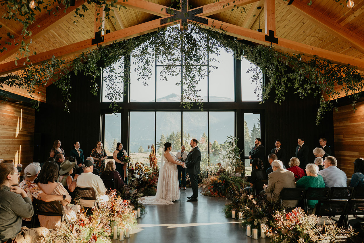 the newlyweds holding hands during their wind mountain ranch wedding ceremony.