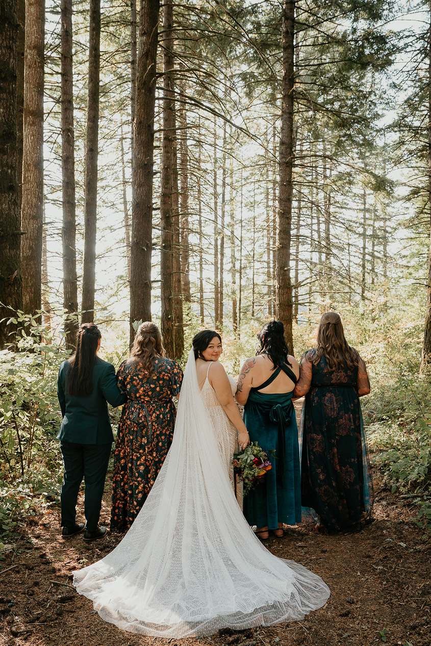 the bride standing in front of her bridesmaids during her wind mountain ranch wedding.