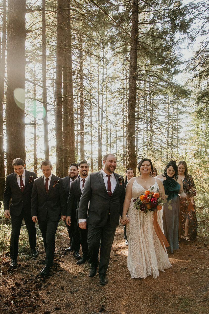 the bride and groom standing in front of their wedding party during their wind mountain ranch wedding.