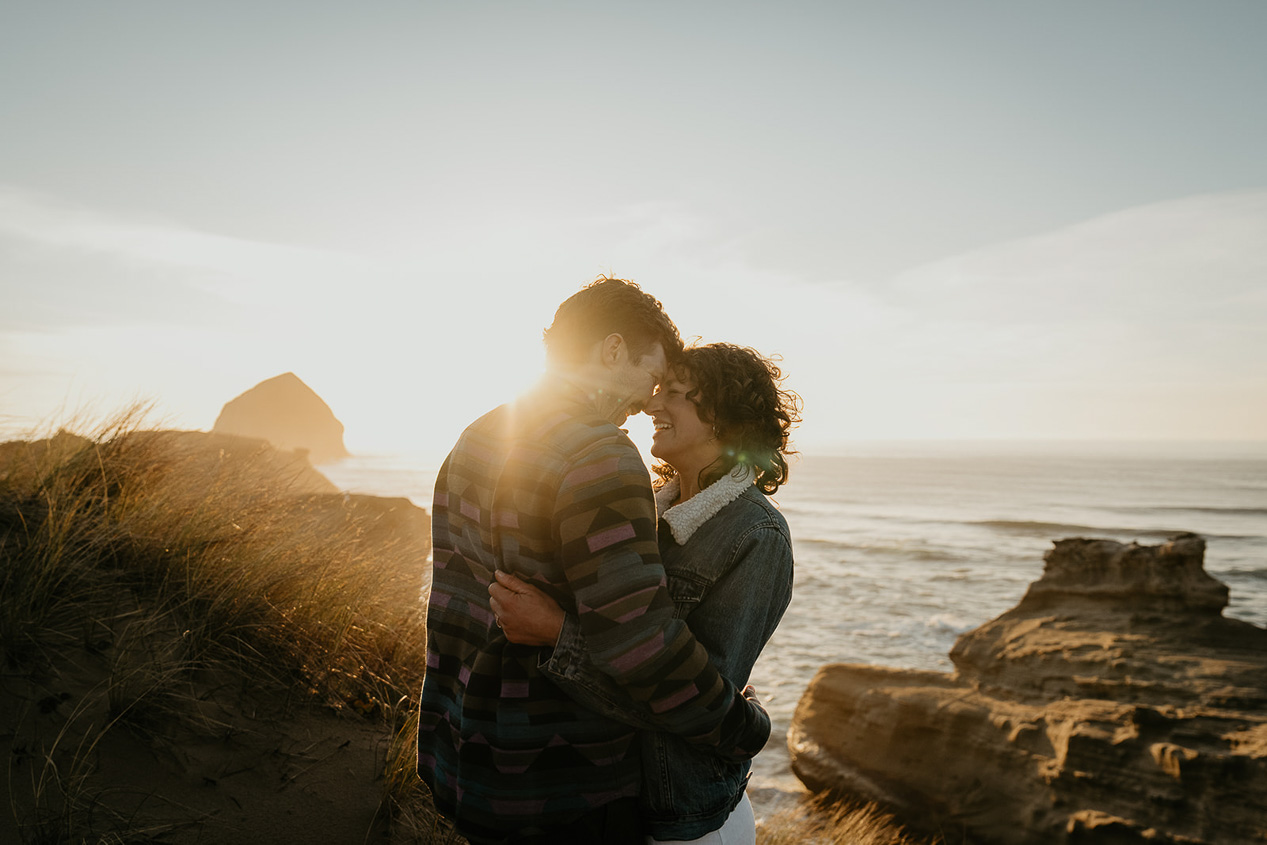 a couple embracing each other as the sun sets during their cape kiwanda engagement.