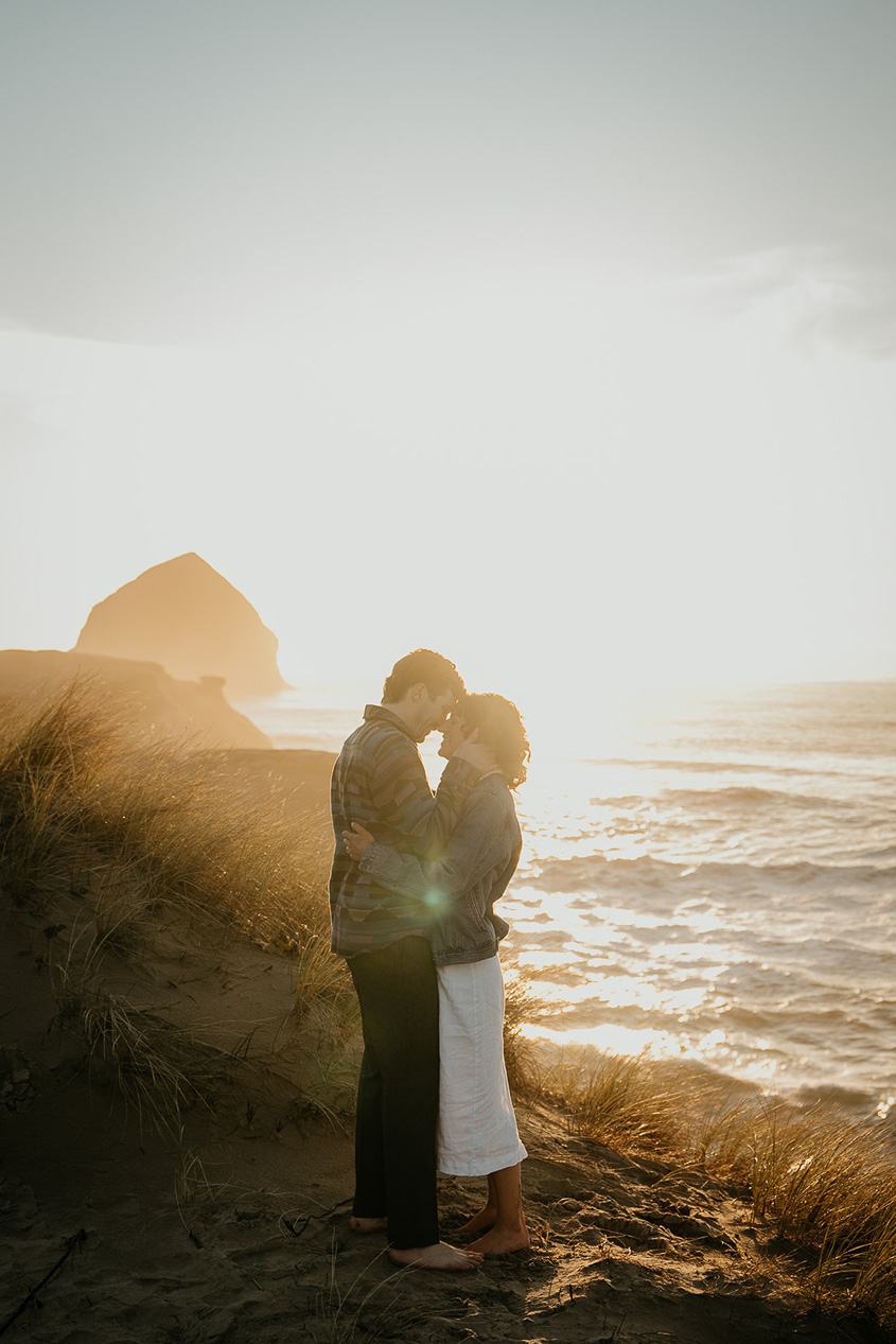 A couple hugging each other as the sun sets during their Cape Kiwanda Engagement.