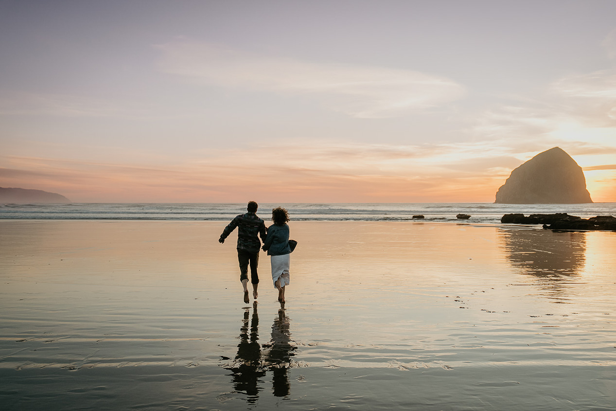 a couple running into the Ocean at sunset during their Cape Kiwanda Engagement.