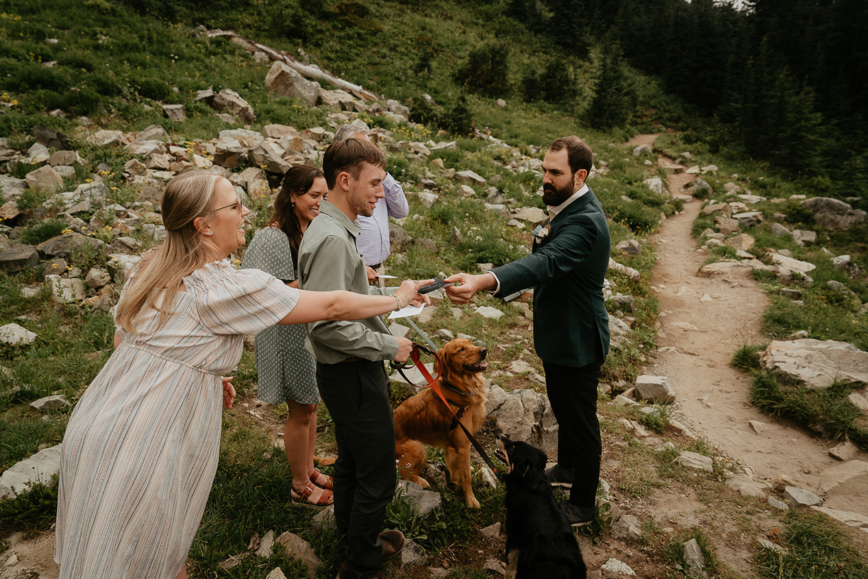 a couple handing out notecards for their elopement guests to read during their ceremony.