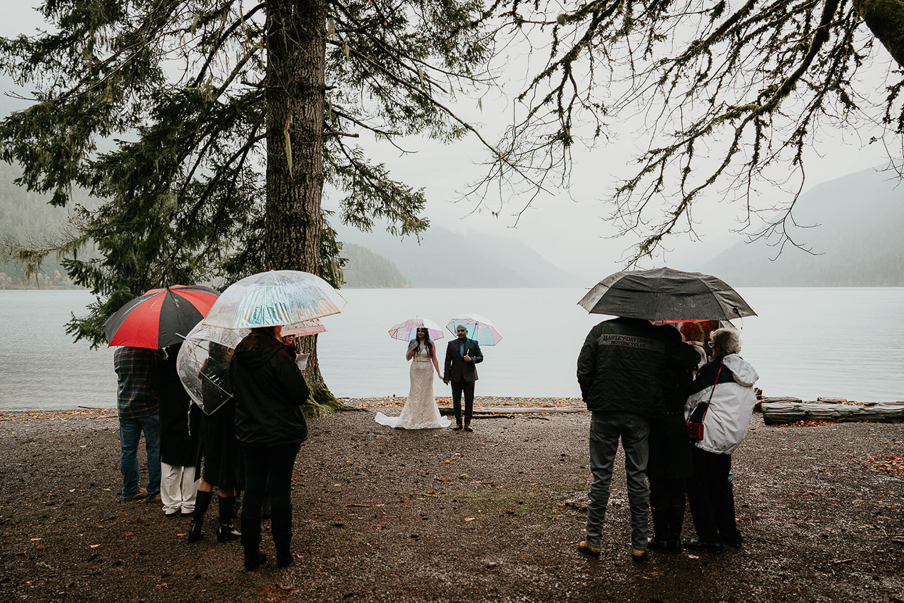 a couple holding their elopement ceremony at lake crescent with their family.