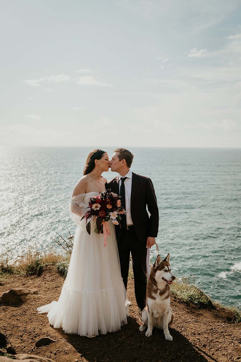 a couple holding their elopement ceremony on the Oregon cliffside with their dog.