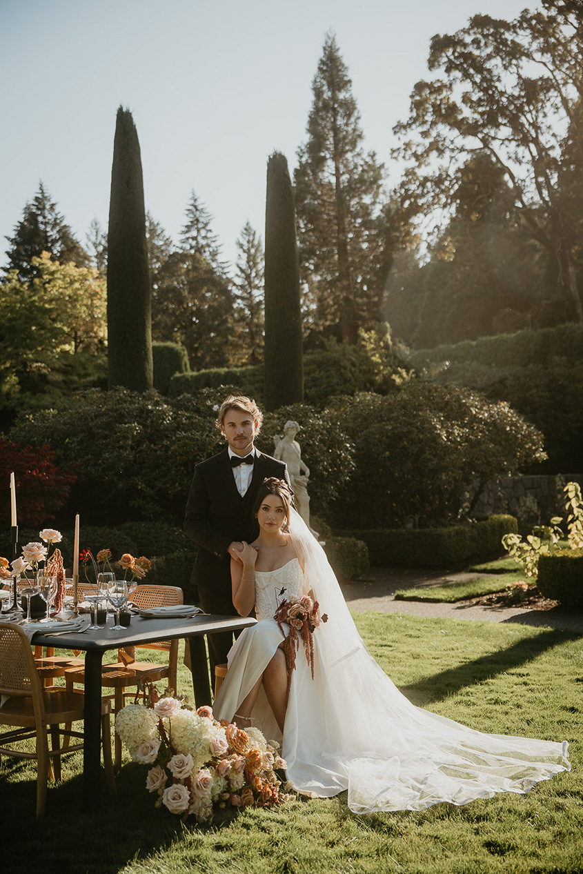 newlyweds sitting on a table in the rose garden during their Chateau de Michellia wedding.