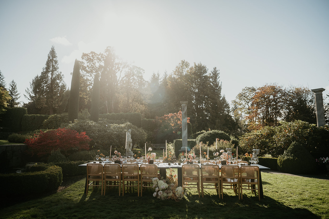 a long, decorated table sitting on a rose garden.