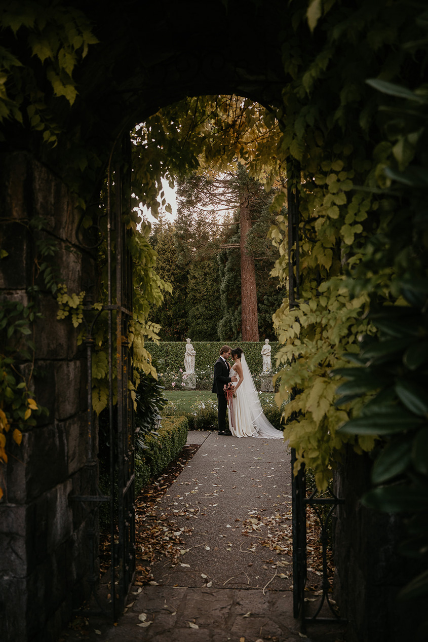 newlyweds kissing in a secluded garden during their Chateau de Michellia wedding.