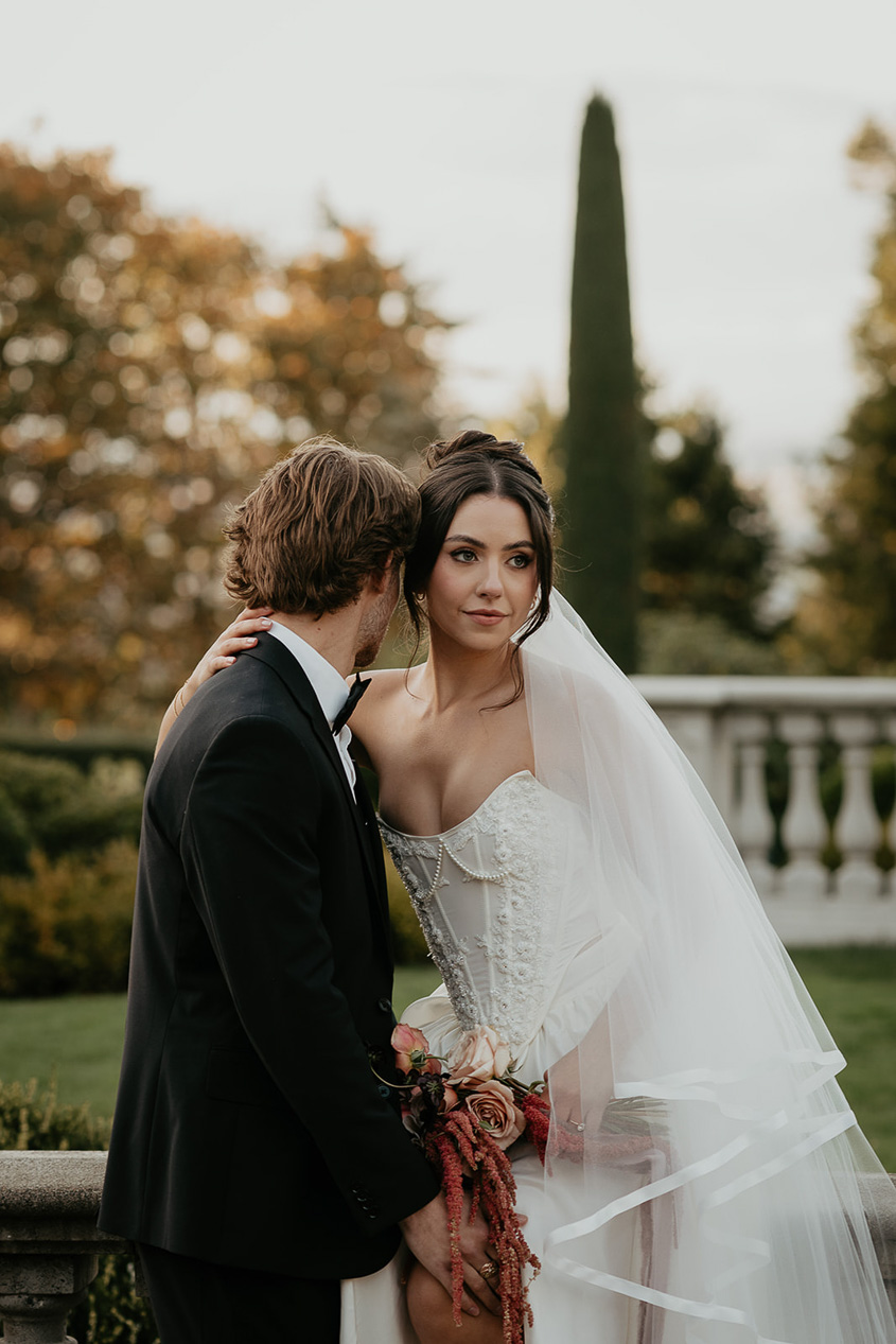 newlyweds kissing on a terrace during their Chateau de Michellia wedding.