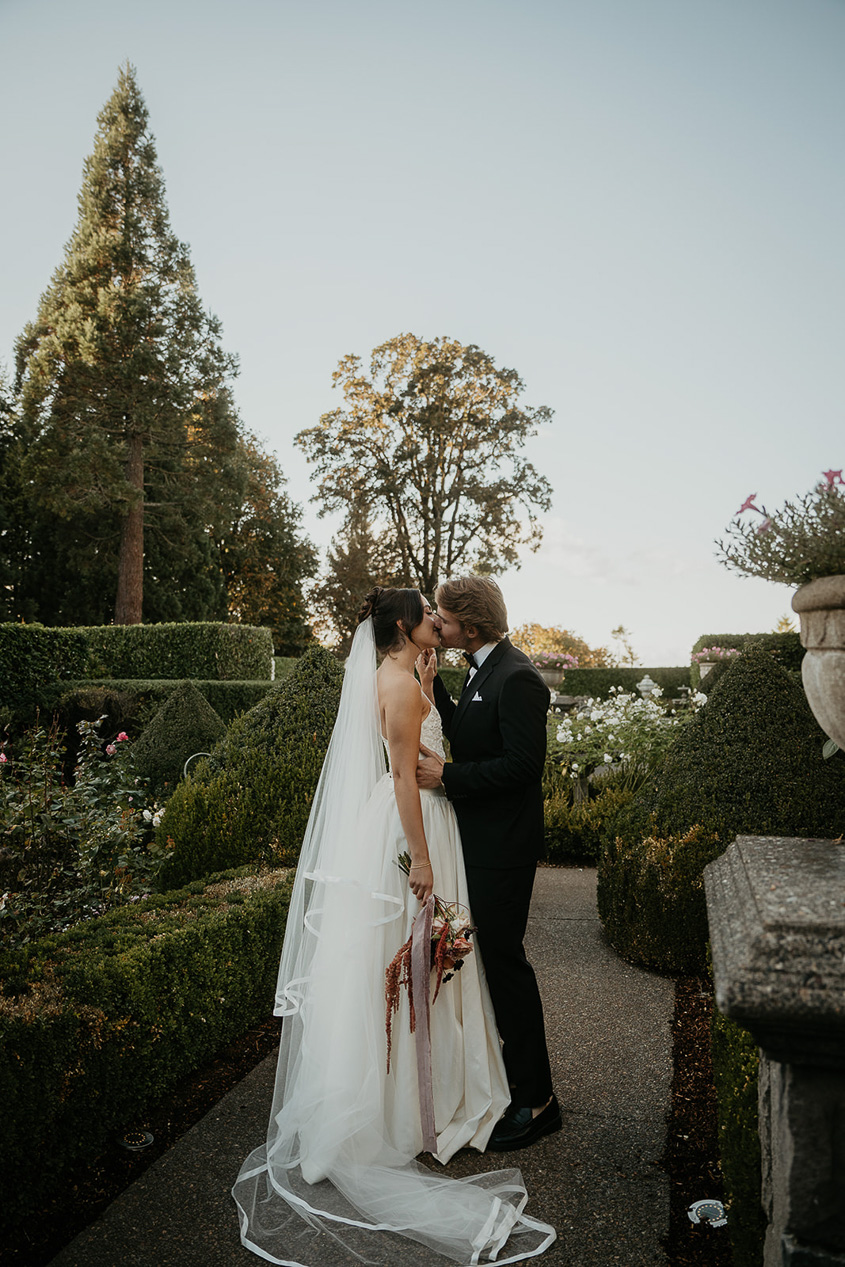 newlyweds kissing on a terrace during their Chateau de Michellia Wedding.