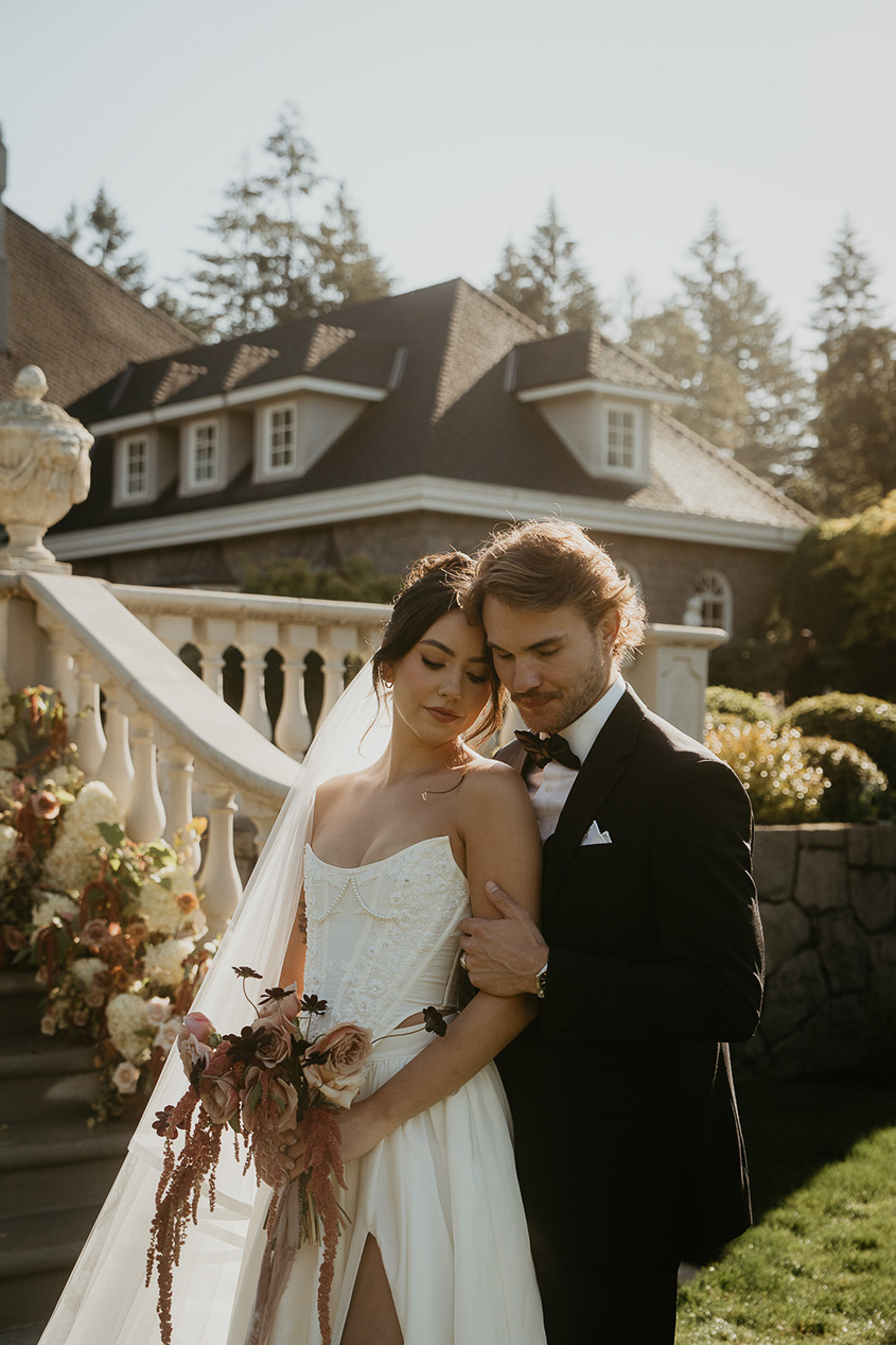 a couple posing outside a staircase during their Chateau de Michellia Wedding