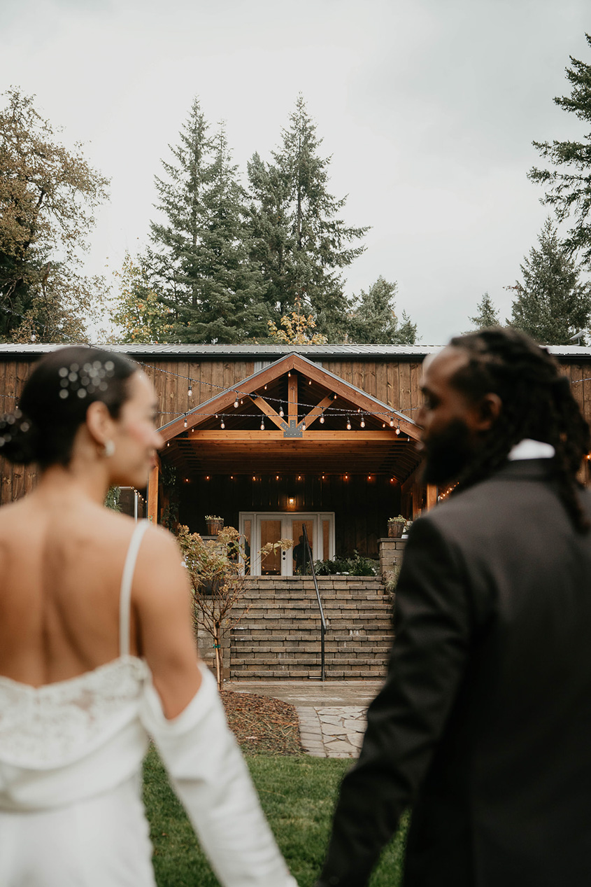 a couple holding hands in front of the rocky hill events building.