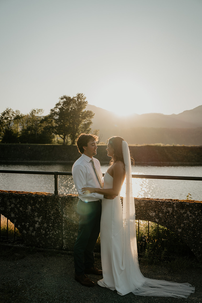 a couple hugging each other at sunset.