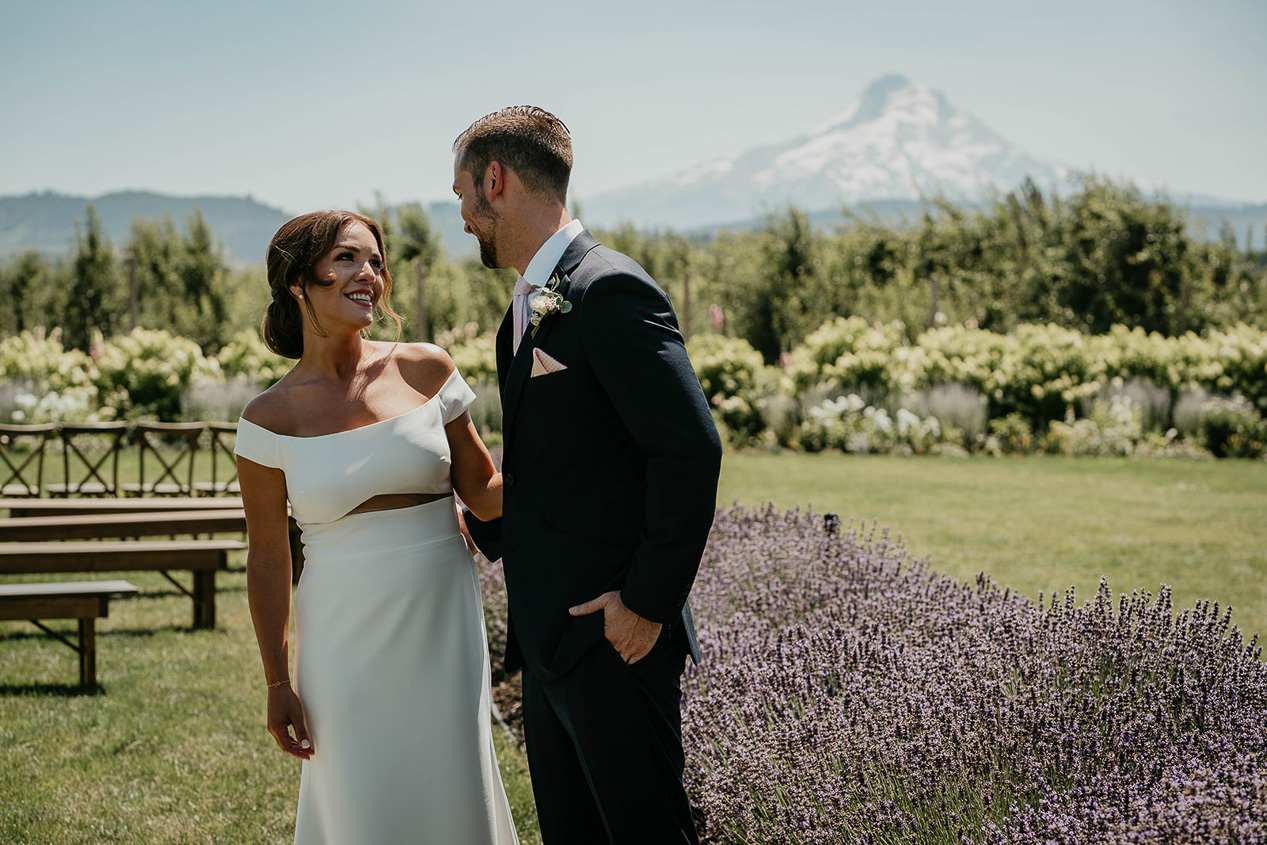 a couple smiling on their wedding day in front of Mt Hood at The Orchard Hood River, one of the best columbia river gorge wedding venues.