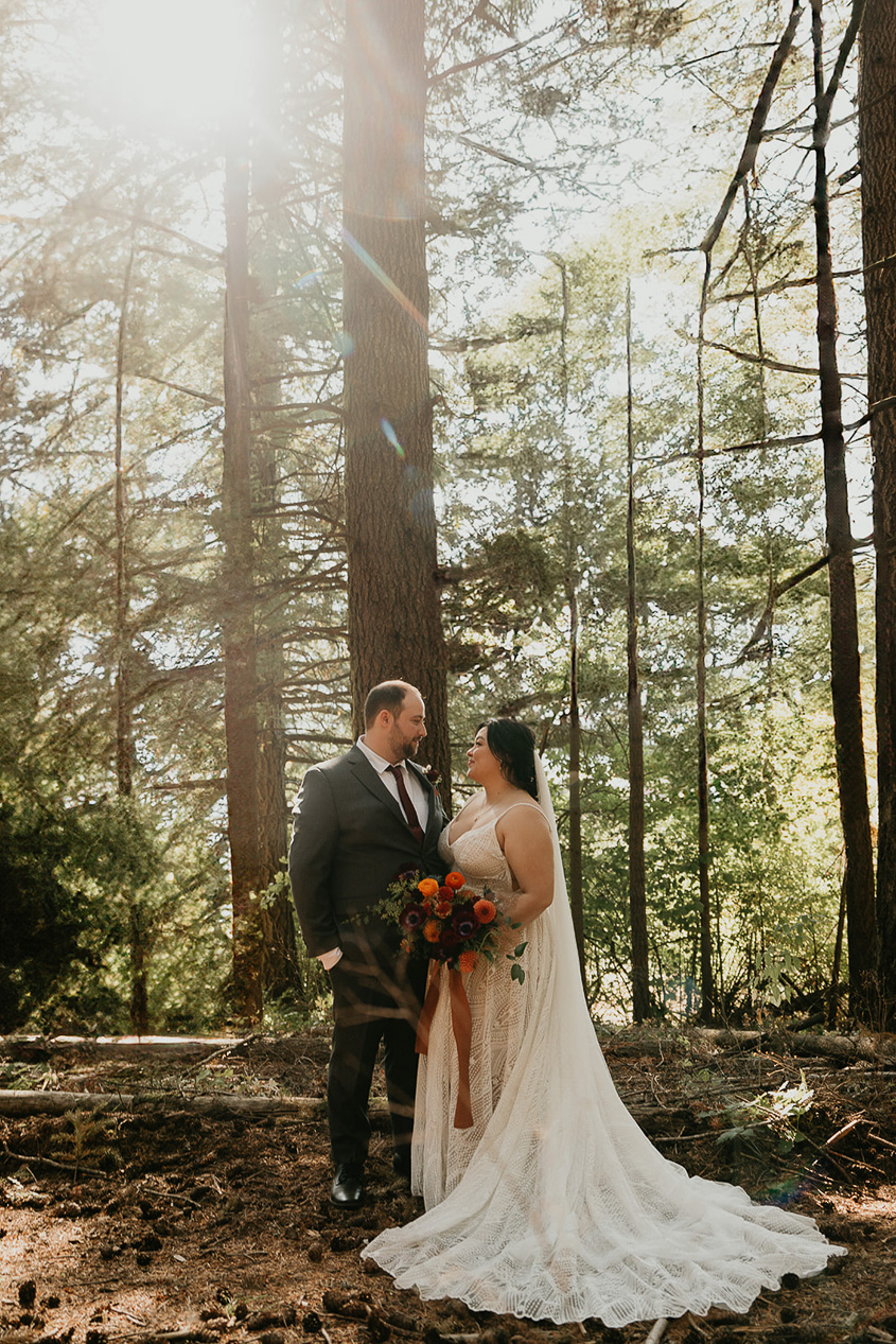 newlyweds embracing each other in a forest at Wind Mountain Ranch, one of the best columbia river gorge wedding venues.