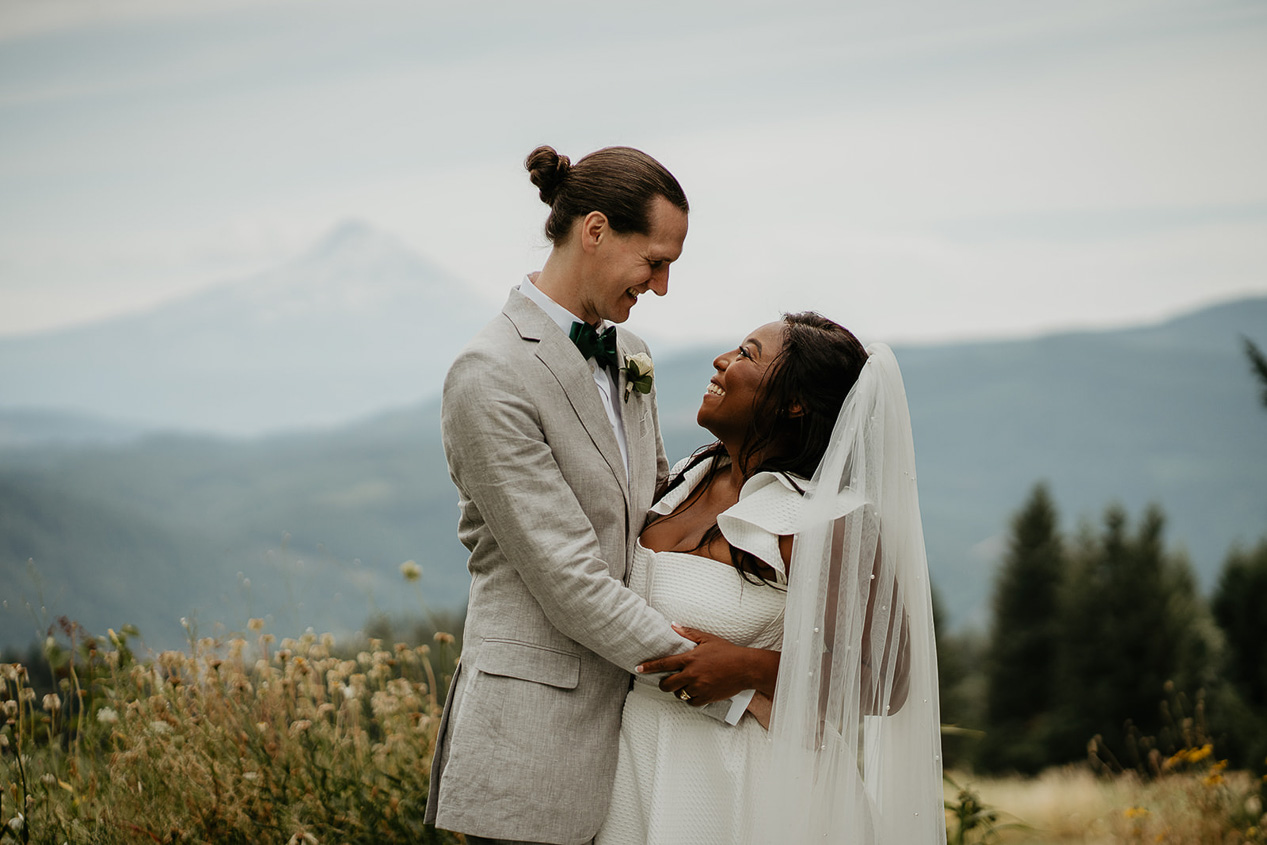 Newlyweds smiling with Mt hood in the background at George Crest Vineyards.