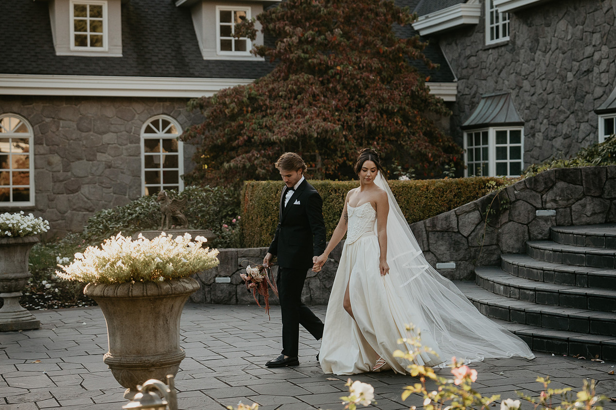 newlyweds holding hands while walking in front of the Chateau de Michellia.