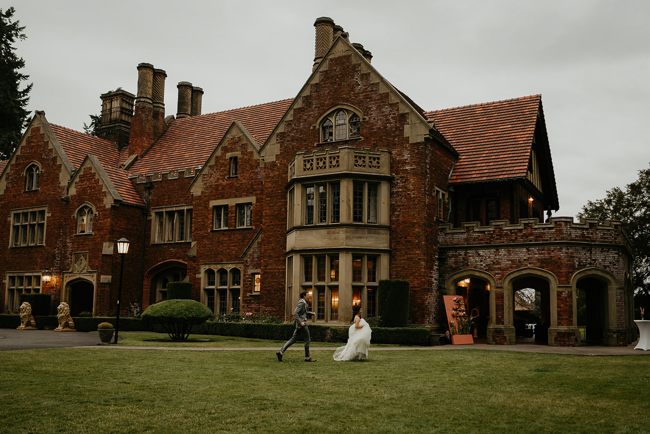 newlyweds running in front of the thornewood castle wedding venue. 