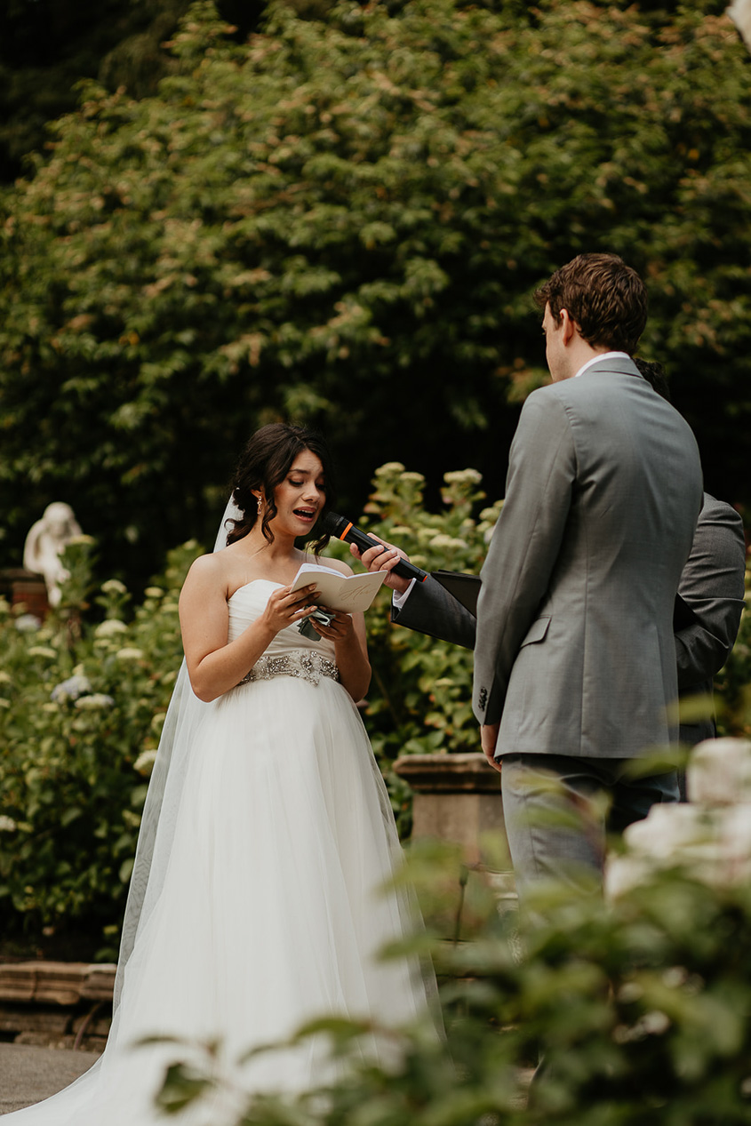 a bride reading her vows to her husband during her thornewood castle wedding ceremony.