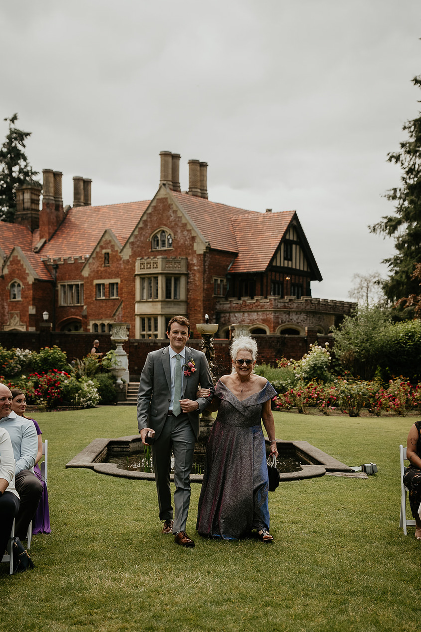 the groom walking down the isle of his thornewood castle wedding.