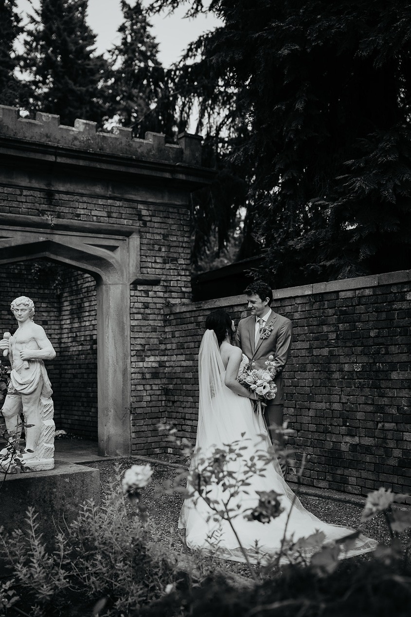 newlyweds holding each other in a garden. 