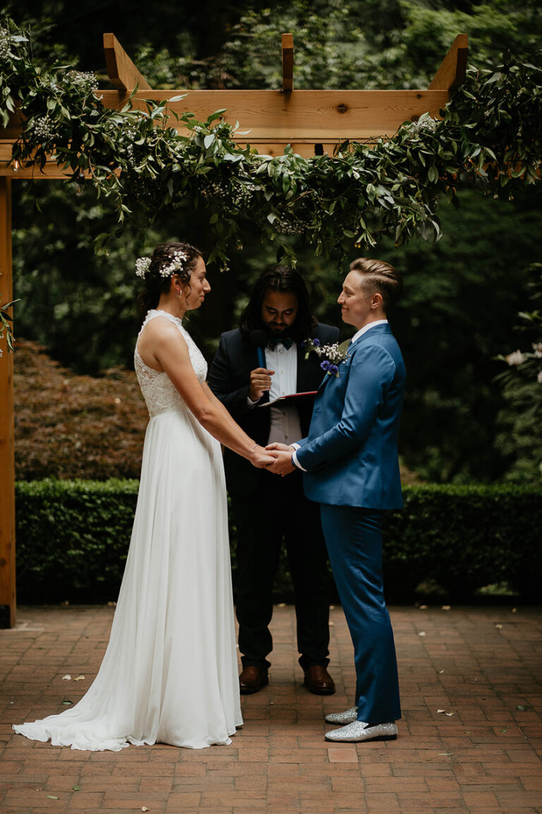 newlyweds holding hands at the altar at Leach Botanical Garden, one of the best wedding venues in Portland.