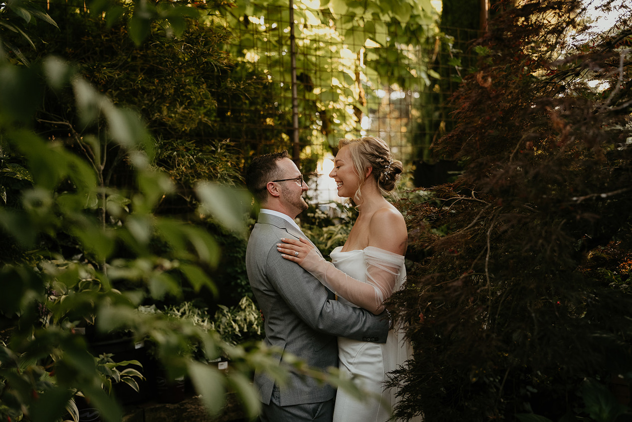newlyweds hugging in the plants at Blockhouse PDX. 