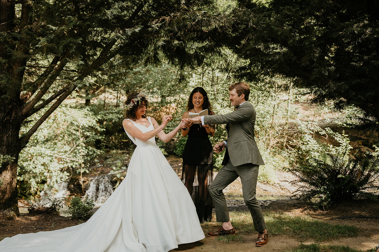 the bride sliding a ring onto the groom's finger during their rustic barn wedding ceremony.