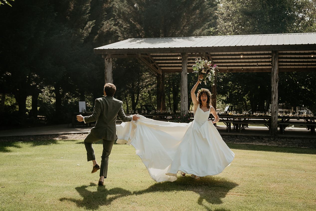 newlyweds dancing on a lawn during their rustic barn wedding.