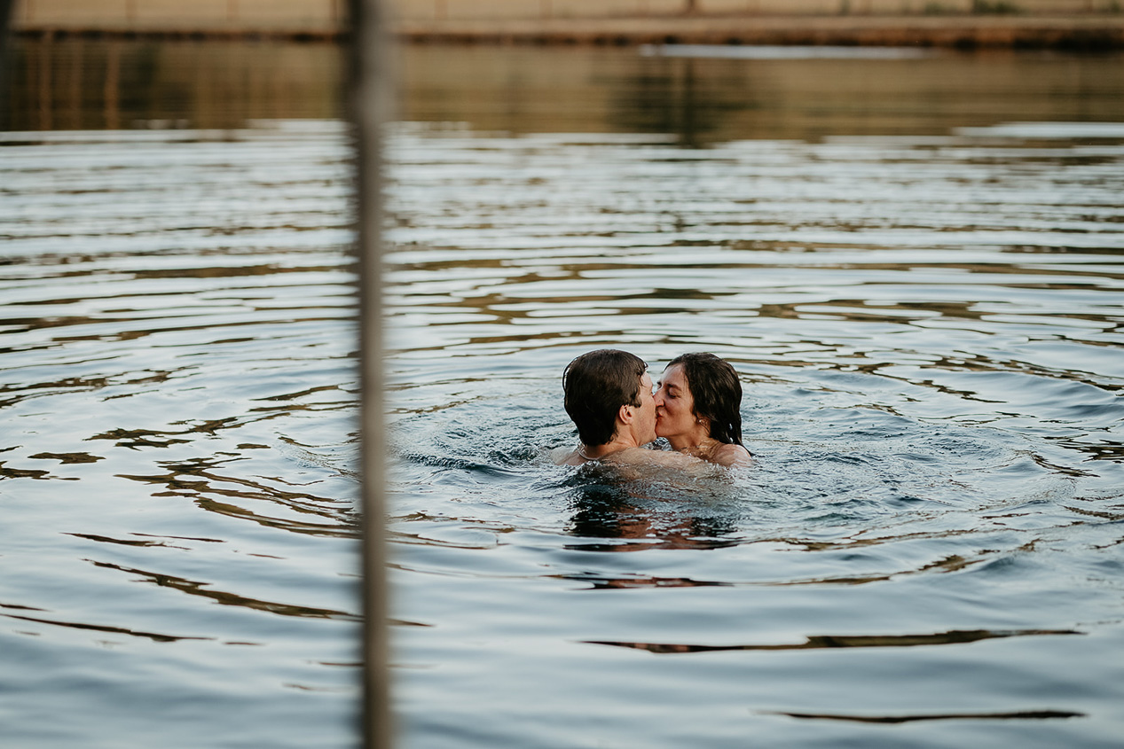 newlyweds kissing in a lake.