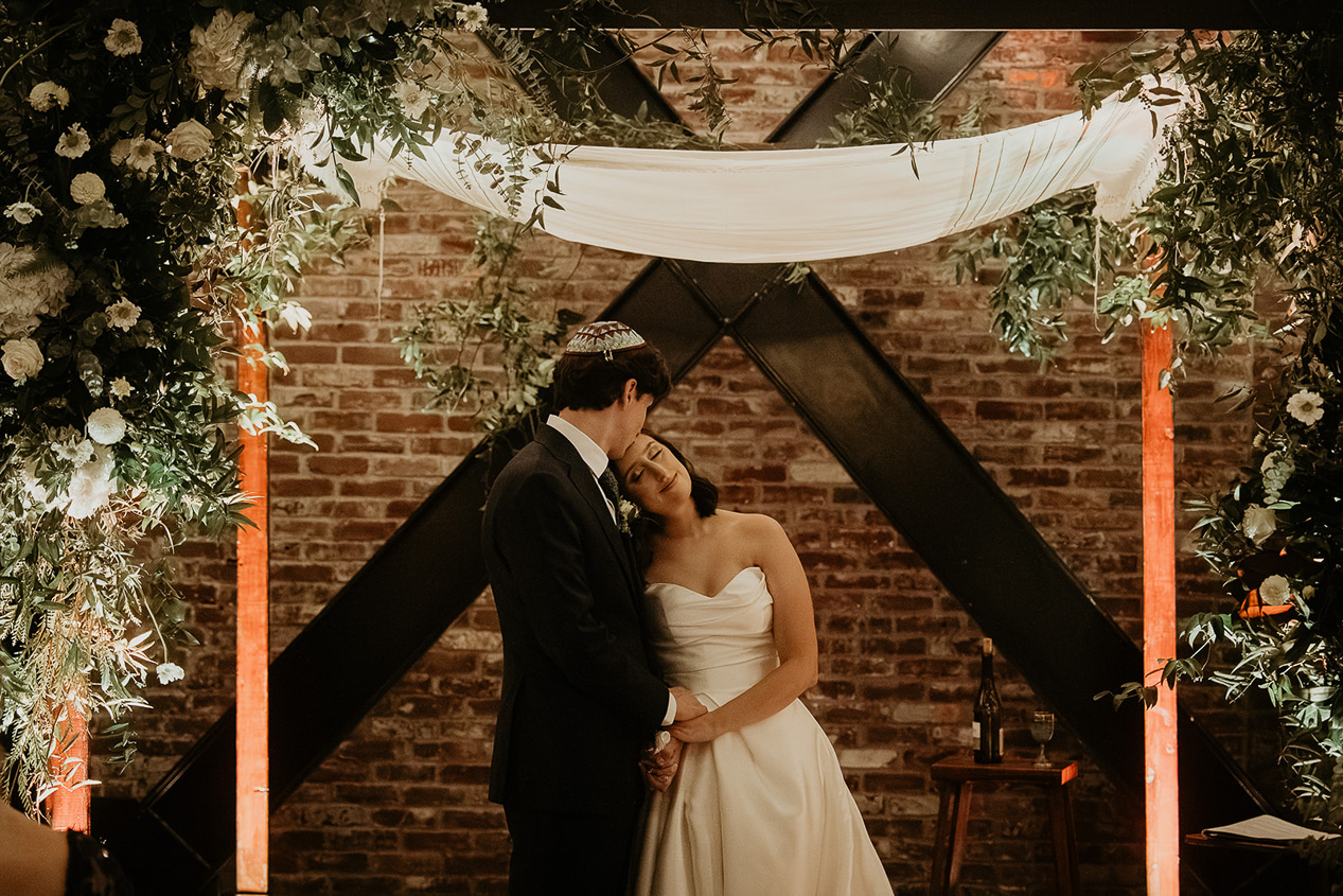 a couple hugging at the altar at The EcoTrust Building. 