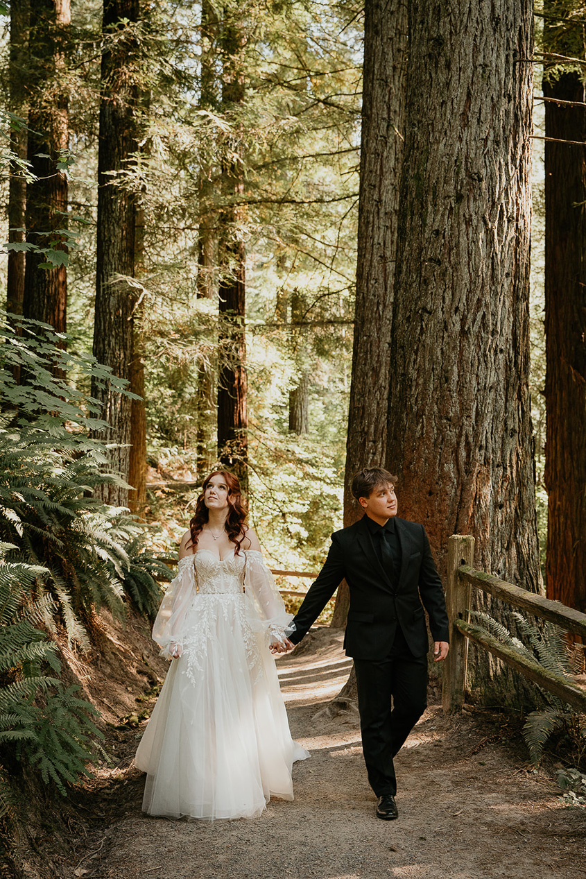newlyweds walking on a trail at Hoyt Arboretum, one of the best wedding venues at Portland.