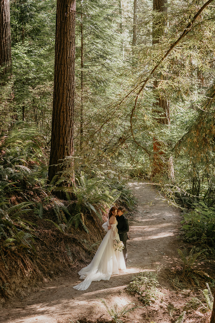 newlyweds kissing on a trail at Hoyt Arboretum, one of the best wedding venues at Portland.