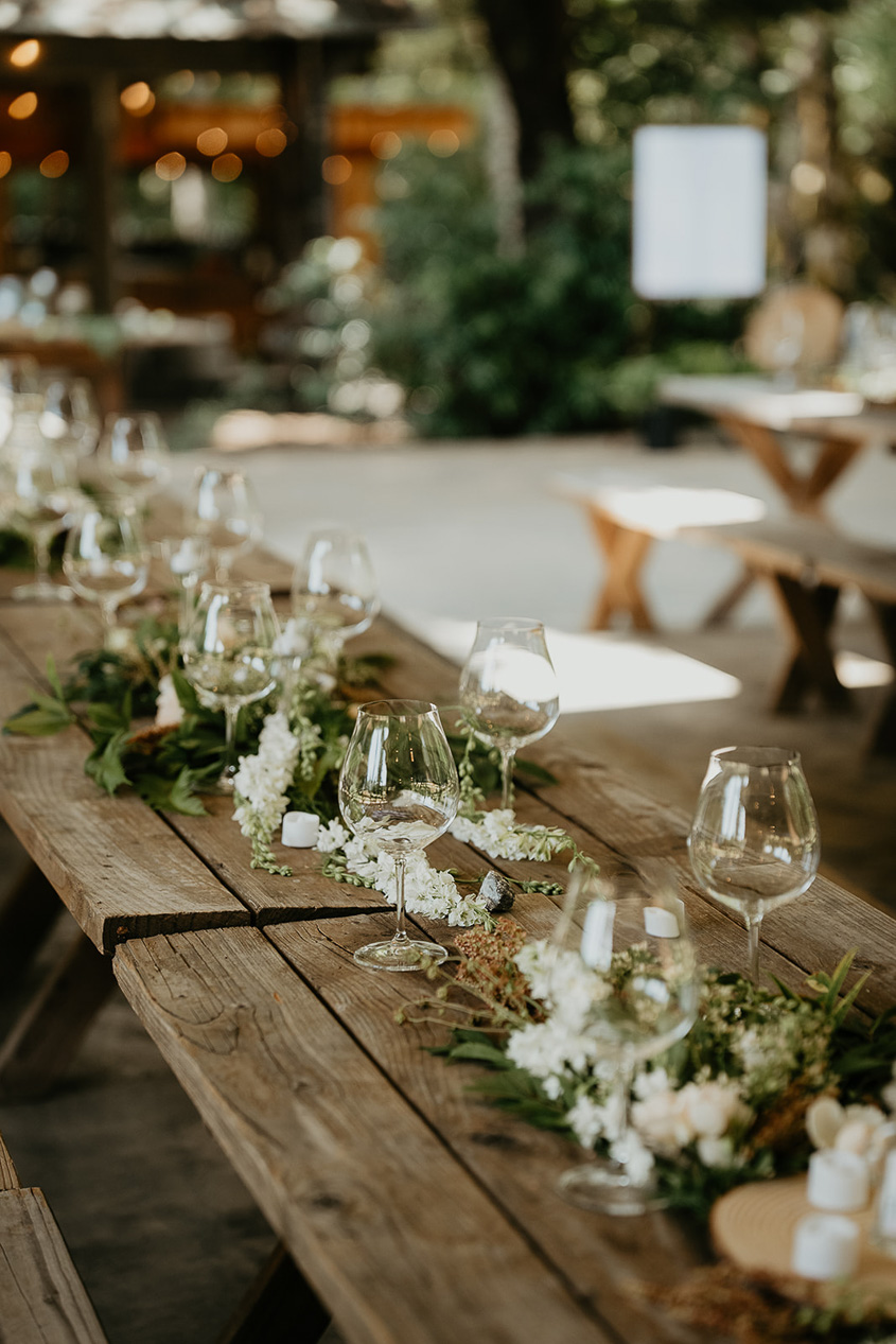 wine glasses and table settings on wooden picnic benches.