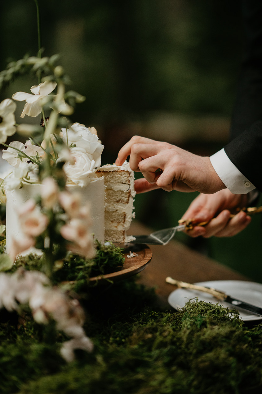the groom taking out a slice of cake.