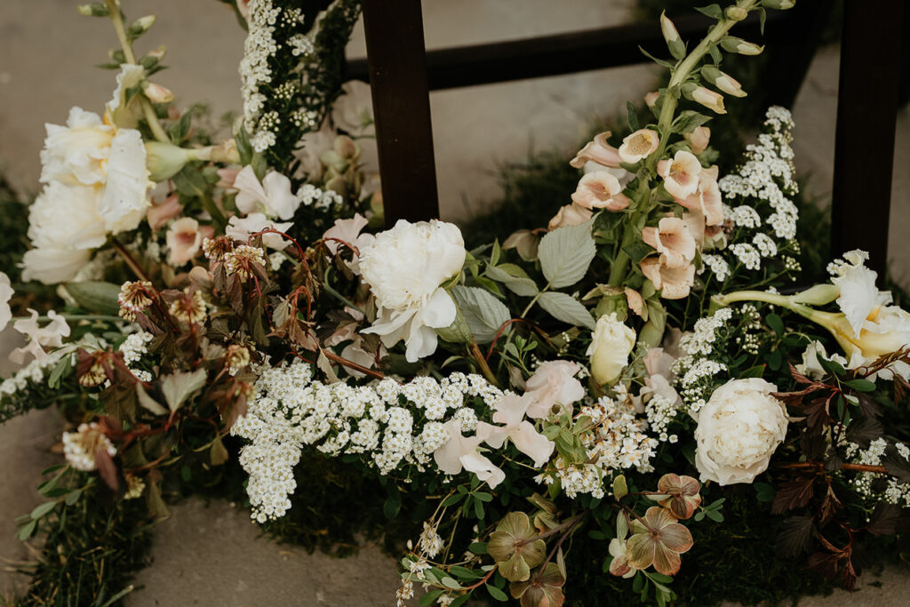 floral arrangements next to a chair during a Highland Farms wedding venue.